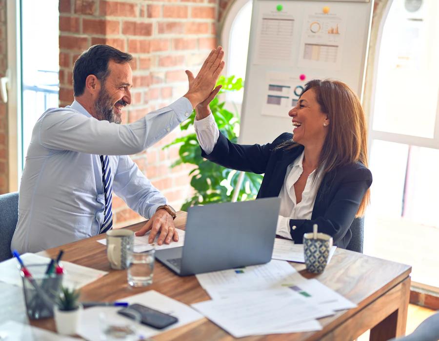 Business owner and consultant celebrating growth results with a high five